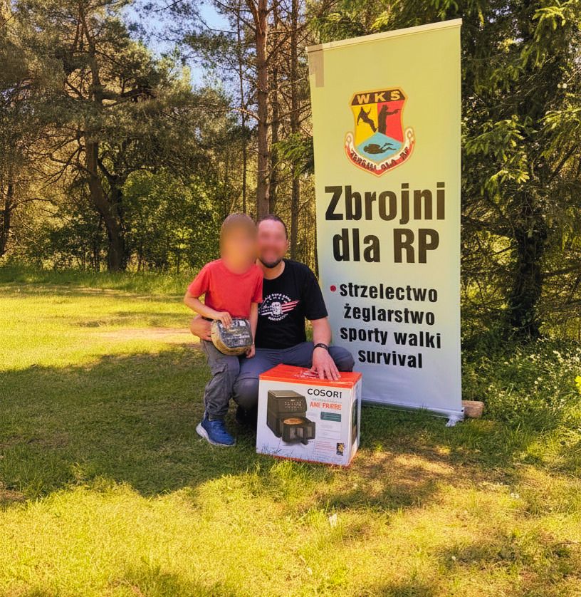 Michał Szufel przy instalacji Hospicjum Pomorze Dzieciom z tabliczką poMOC uskrzydla Gdańsk